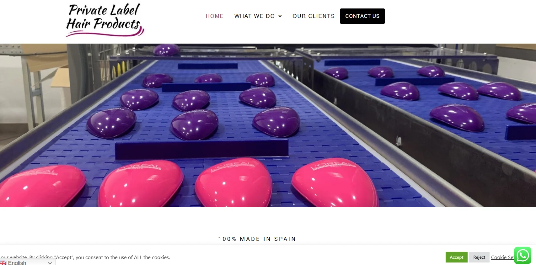 Conveyor line with purple and pink hair brushes in a manufacturing facility, labeled with a hair product brand.